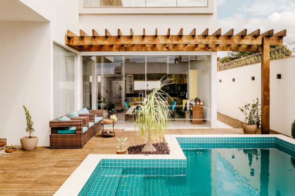 Pergola - brown wooden table near swimming pool