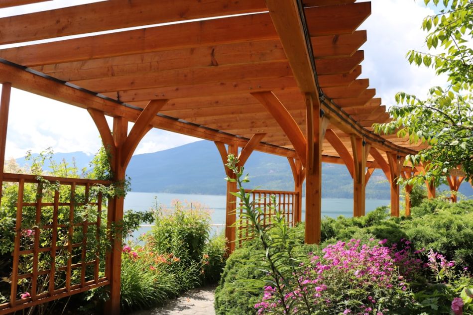 Pergola - brown wooden bridge over body of water during daytime